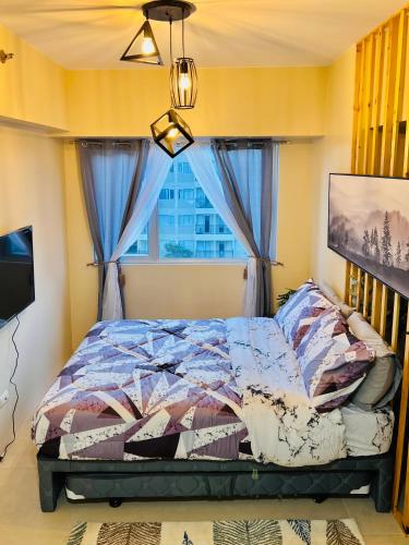 a bedroom with a bed and a window at * *P Fantastic 2BR Option for 8 in Iloilo City