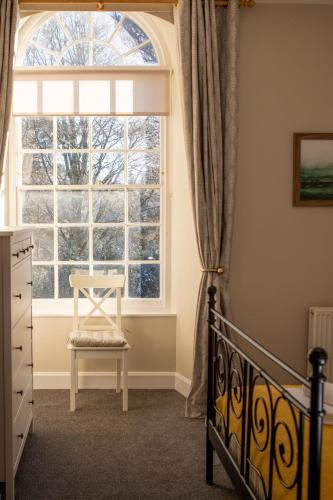 a bedroom with a crib and a large window at The Bothy at Bowhill in Selkirk
