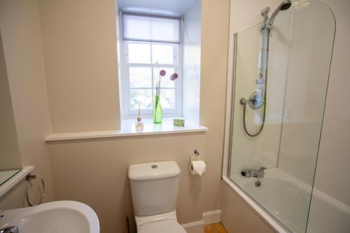 y baño con aseo, lavabo y ducha. en The Bothy at Bowhill en Selkirk