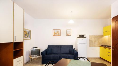 プーラにあるCasa Vacanze Mulvoni Aiosardegnaのリビングルーム(青い椅子、冷蔵庫付)