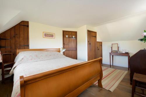 a bedroom with a large bed with a wooden frame at The Thatch in Chipping Campden