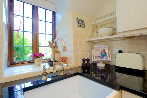 a kitchen with a sink and a window at The Thatch in Chipping Campden