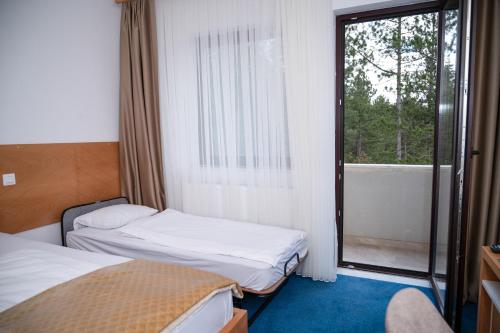 a hotel room with two beds and a window at Hotel Borovi Forest Resort & Spa in Sjenica
