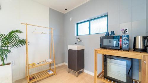 a living room with a tv on a table at Jeju Dalbam Pension in Seogwipo