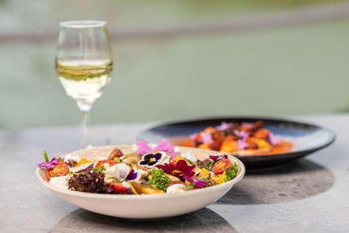 a bowl of food and a glass of wine on a table at Hotel Vista Lago 