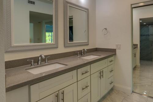 uma casa de banho com dois lavatórios e dois espelhos em Sunny Palm Springs Townhome with Pool Access! em Palm Springs