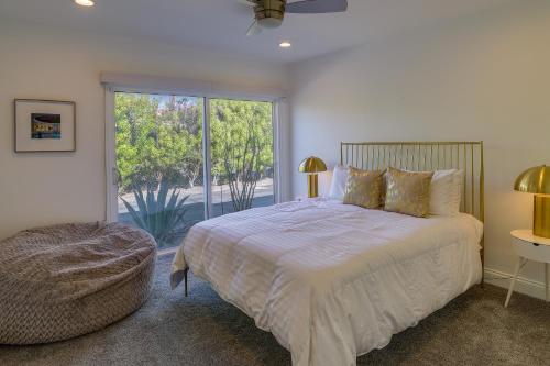 um quarto com uma cama e uma grande janela em Sunny Palm Springs Townhome with Pool Access! em Palm Springs