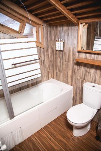a bathroom with a white tub and a toilet at Alto Melimoyu Hotel & Patagonia in La Junta