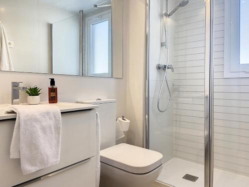 a white bathroom with a shower and a toilet at Via Celere 2329 Luxury apartment with Sea View in Casares