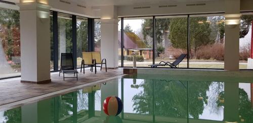 a house with a swimming pool and glass windows at Fontána Lipno in Černá v Pošumaví