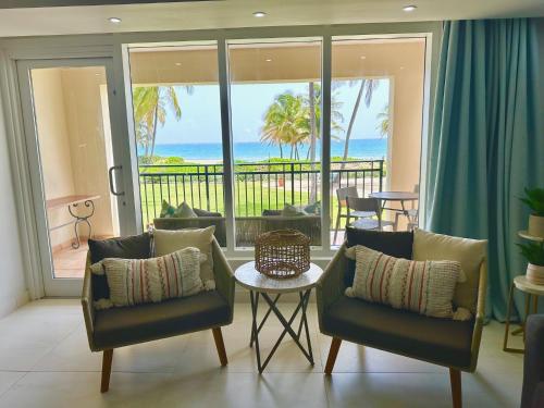 sala de estar con sillas y mesa con vistas al océano en Beachfront Villa in the Rio Mar Resort, en Río Grande