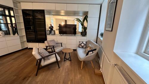 a living room with two chairs and a tv at Fabelagtig lejlighed R8 in Copenhagen