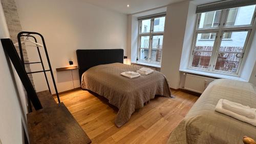 a living room with a bed and two windows at Fabelagtig lejlighed R8 in Copenhagen