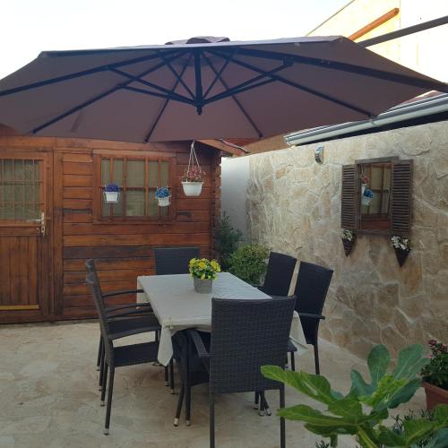 a table and chairs under an umbrella on a patio at Villa Susann in Šibenik