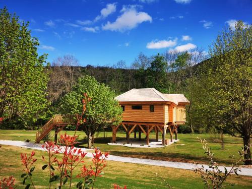 a log cabin in the middle of a yard at Les Cabanes Suspendues in Satillieu