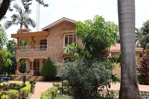 a house with a palm tree in front of it at Mama Thea homes in Moshi