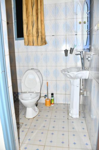 a bathroom with a toilet and a sink at Enchante Suites Kigali in Kigali