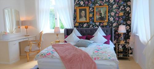 um quarto com uma cama com um monte de almofadas em VILLA FREIA Dresden - Exklusive Ferienwohnung zum Erholen & Entspannen em Dresden
