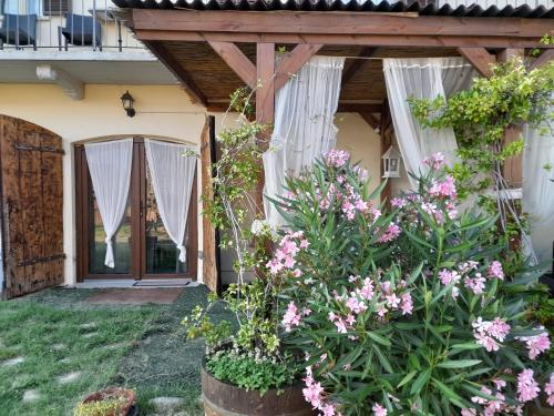 una casa con flores delante de una puerta en Madama Langa Country House con piscina nelle vigne en Montelupo Albese