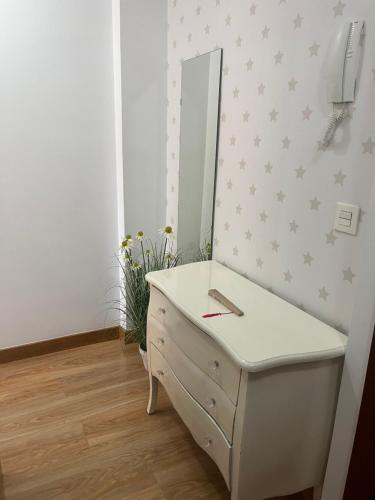 La salle de bains est pourvue d'une commode blanche et d'un miroir. dans l'établissement Bonito apartamento en Granada (zona palacio congresos y metro), à Grenade