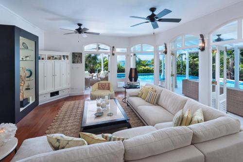 a living room with white furniture and a pool at Hectors House Blue Sky Luxury in Christ Church