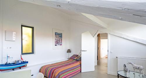een slaapkamer met een bed in een kamer met witte muren bij L'Avray in Ville-dʼAvray