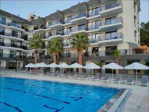 een hotel met een zwembad voor een gebouw bij New apartment with pool near the sea in Akbük