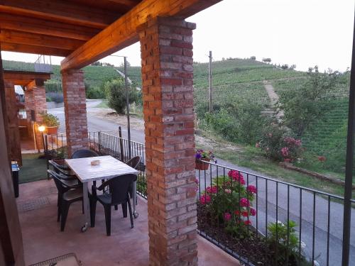 a patio with a table and chairs and a fence at Madama Langa Country House con piscina nelle vigne in Montelupo Albese
