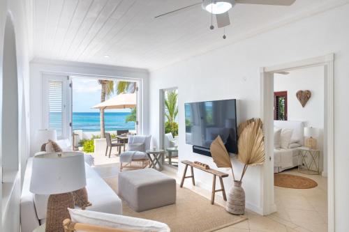 a living room with a view of the ocean at Exceptional Beachfront Living - Milord Sunsets home in Saint James