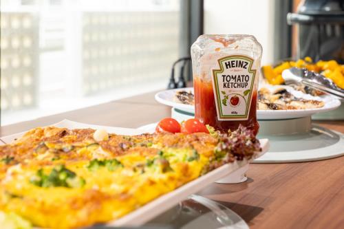 a table with a pizza and a can of tomato ketchup at Hotel Sun in Takasaki