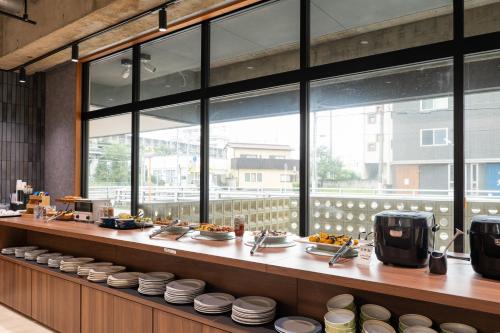 a restaurant with a counter with plates of food at Hotel Sun in Takasaki
