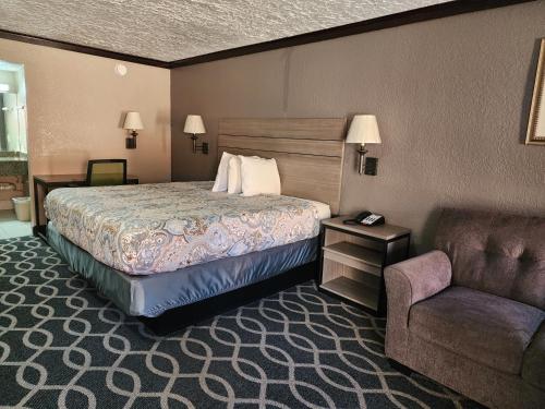 um quarto de hotel com uma cama e uma cadeira em Executive inn em Oklahoma City