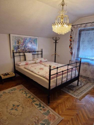 a bedroom with a bed and a chandelier at Apartment Kula in Gračanica