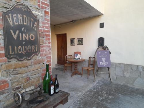 a wine cellar with a sign and a table with wine bottles at Madama Langa Country House con piscina nelle vigne in Montelupo Albese