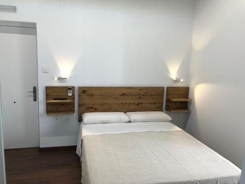 1 dormitorio con 1 cama y 2 luces en la pared en Cero estrellas Cabildo en Sanlúcar de Barrameda