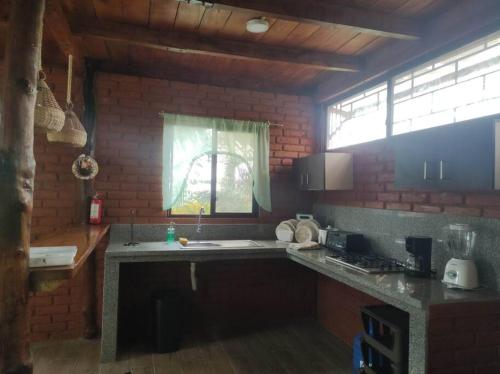 uma cozinha com um balcão com um lavatório e uma janela em Cayo Ecovillage em Puerto Cayo