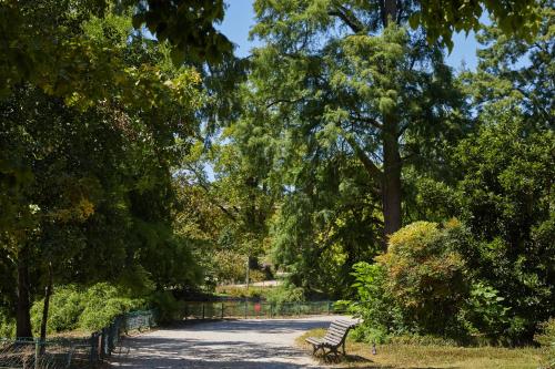 a park bench sitting on a path in a park at Hotel Indigo Bordeaux Centre Chartrons by IHG in Bordeaux