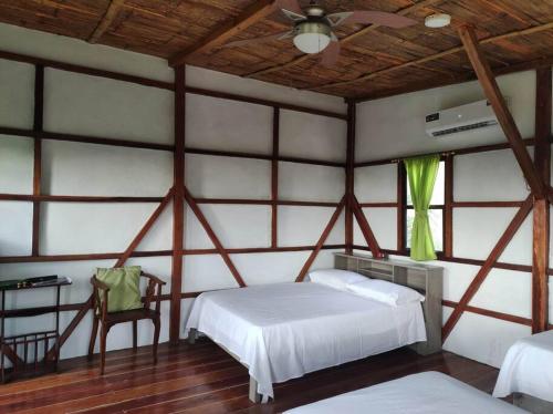 um quarto com uma cama branca e uma janela em Cayo Ecovillage em Puerto Cayo