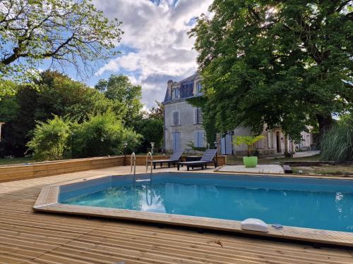 een zwembad op een houten terras bij Château de Champblanc in Cherves-de-Cognac