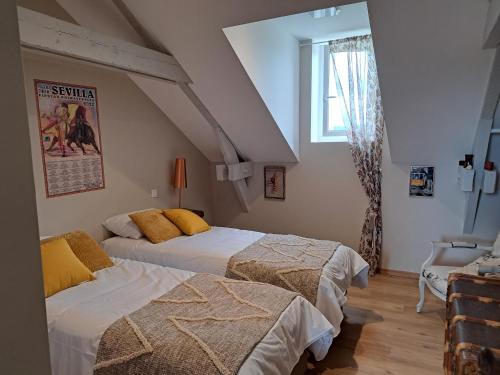 a bedroom with two beds and a window at au milieu coule la Garonne 