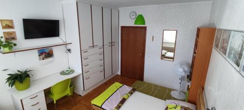 a small room with a bedroom with a desk and a tv at Zelený pokoj in Mohelnice