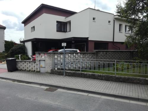 une maison blanche avec une clôture devant elle dans l'établissement Zelený pokoj, à Mohelnice