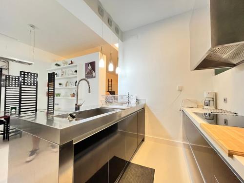 eine Küche mit einer Spüle aus Edelstahl und einer Theke in der Unterkunft Exclusivo Piso Madrid Mendizabal in Madrid