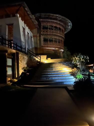 a set of stairs in front of a building at night at Willing Resort, Trongsa in Kagha