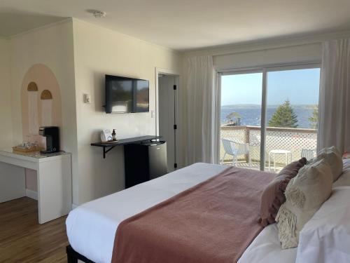 a bedroom with a bed with a view of the ocean at The Marmalade Motel in Port Dufferin