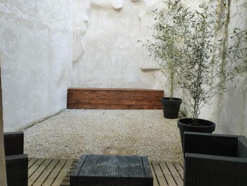 une chambre avec deux plantes en pot et un banc dans l'établissement Appartement avec terrasse, à Malaucène