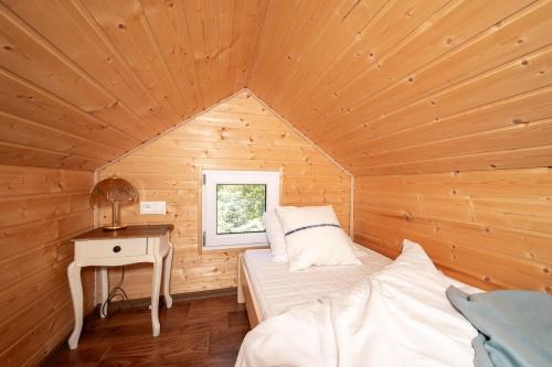 a bedroom with a bed in a wooden cabin at Białe Żagle - domki nad morzem in Kopań