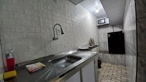 - une petite cuisine avec évier dans la chambre dans l'établissement Suíte Aconchegante em Hospedaria no Centro, à Ouro Preto