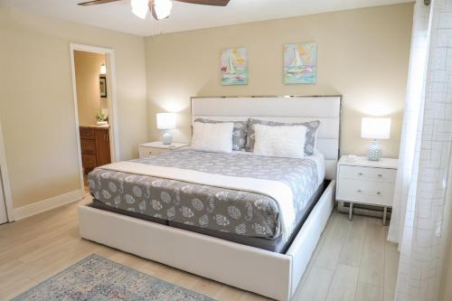 拉哥的住宿－Sunnyside Palms - 2BR, Poolside, 5 min to Beach，一间卧室设有一张大床和两个床头柜