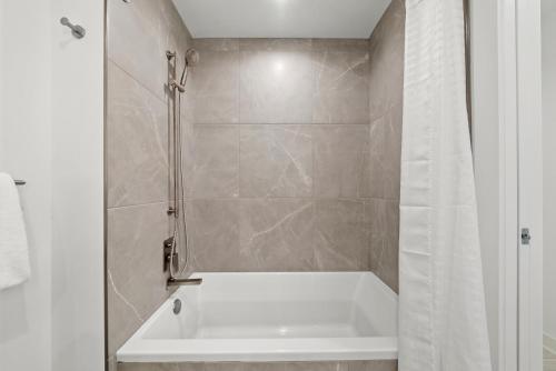a white bath tub in a bathroom with a shower at Level Chicago - Fulton Market in Chicago